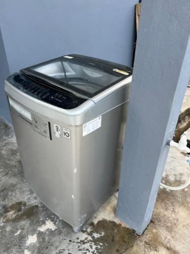 a washing machine sitting next to a wall at NovaHaus2 Homestay Gong Badak in Kuala Terengganu