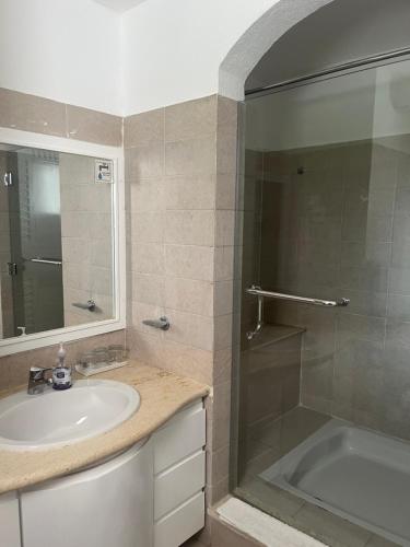 a bathroom with a sink and a shower and a tub at Domina Coral Bay Harem Luxury in Banī Ghālib