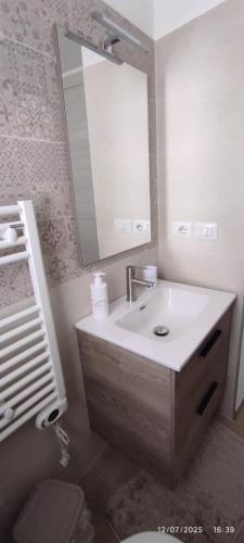 a bathroom with a sink and a mirror and a toilet at Casa Sofia in Condrò