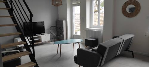a living room with a chair and a table and a television at Maison 3 chambres avec jardin Gien in Gien