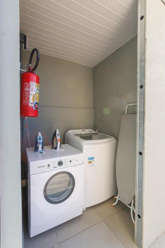 a laundry room with a washing machine and a washer at Lou Suítes - Suíte 05 - Essência do Silêncio in Guarapuava