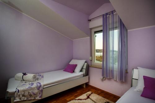 een kleine kamer met 2 bedden en een raam bij Rogoznica Apartments Kristina in Rogoznica