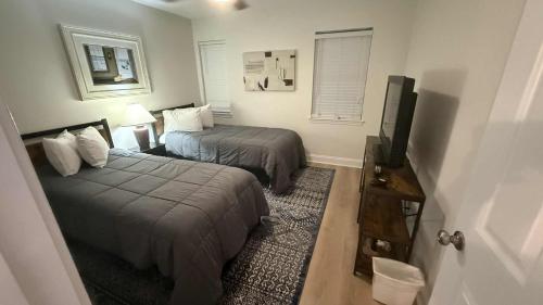 a hotel room with two beds and a flat screen tv at 2Br 2Ba Condo on Golf Course in Pawleys Island