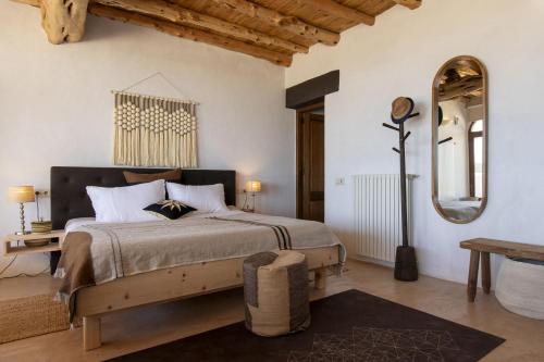 een slaapkamer met een groot bed en een spiegel bij Finca del Cielo in San Jose