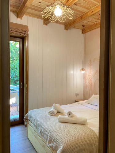 a bedroom with a bed with two towels on it at Zloty, a Skromny - ogrodzony domek z jacuzzi i widokiem na jezioro in Górzno