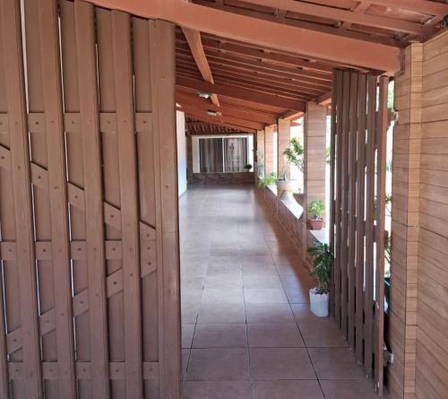 an internal hallway of a building with wooden doors at pousada marimar in Icapuí