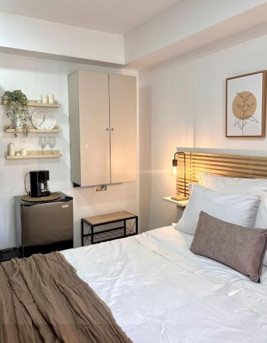 a bedroom with a white bed and a kitchen at BIT by Simple stay in Medellín