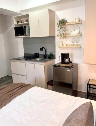 a small kitchen with white cabinets and a sink at BIT by Simple stay in Medellín