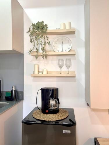 a kitchen with a coffee maker and two wine glasses at BIT by Simple stay in Medellín