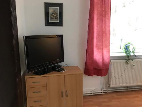 a flat screen tv sitting on top of a wooden cabinet at Ferienwohnung Zur Weißen Taube in Dobbertin