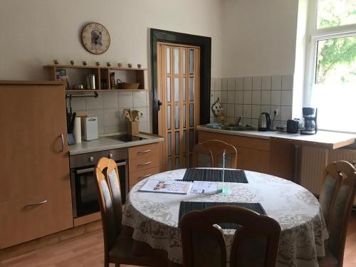 a kitchen with a table and chairs and a table and a table and a kitchen at Ferienwohnung Zur Weißen Taube in Dobbertin