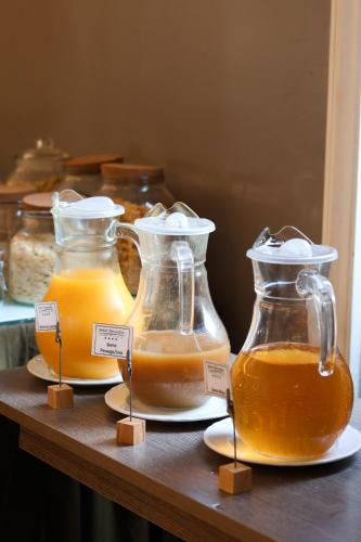 Tres frascos de vidrio con miel en un estante de madera. en Hotel Bienestar Termas De Vizela, en Vizela
