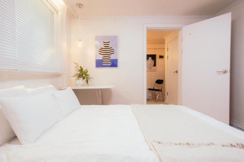 a bedroom with a white bed and a table at 반포레스트 room3 in Seoul