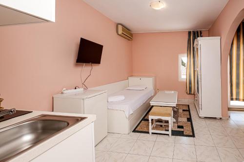 a bathroom with a sink and a bed in a room at Family Hotel Paros 2 in Pomorie