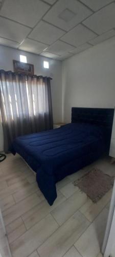 a bedroom with a blue bed in a room at Lam DEPARTAMENTO TEMPORARIO in Resistencia