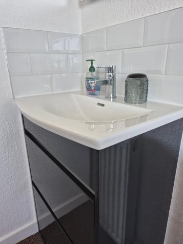 a white sink in a bathroom with white tiles at Firthview House in Kirn