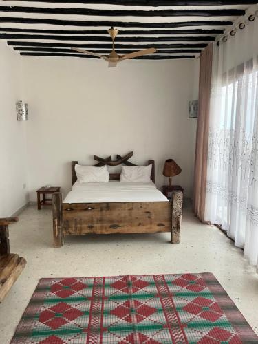 a bedroom with a bed and a rug on the floor at Malcom Ocean View Retreat in Pongwe