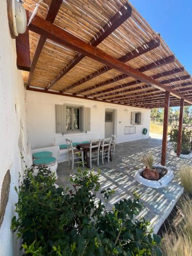 a patio with a table and chairs under a wooden pergola at Casa Paros in Parikia