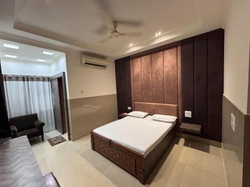 a bedroom with a bed and a chair in it at Hotel Ashirwad, Chandni Chowk in New Delhi