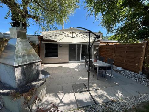 a patio with a table and an umbrella at Newly renovated 2 bedroom holiday home in Cheyres in Cheyres