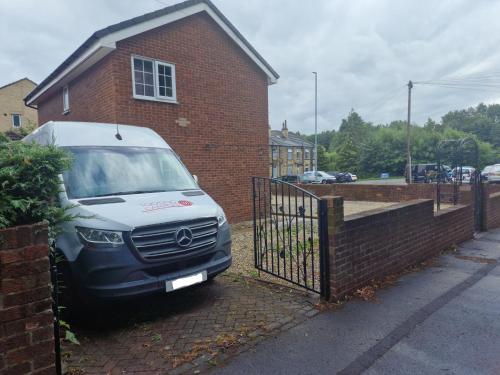 a car parked in front of a brick house at 3-Bed Detached House Private Drive for Two Cars in Farsley