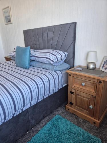 a bedroom with a bed and a nightstand with a blue pillow at Firthview House in Kirn