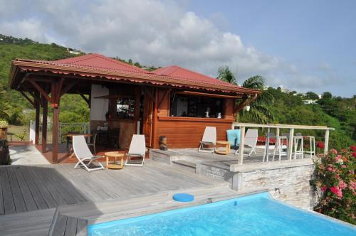 a house with a deck and a swimming pool at Infiniti Blue in Bouillante