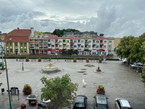 a large courtyard with cars parked in front of buildings at Rezydencja Szatkowskich in Barlinek
