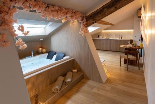 une salle de bain avec une baignoire au milieu d'une pièce dans l'établissement CEVA Suite Sakura - Jacuzzi & Cinéma Centre ville, à Saint-Étienne