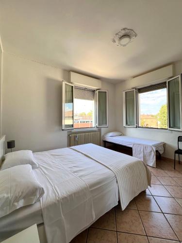 a bedroom with two beds and two windows at Locanda Casa Ascari in Nonantola