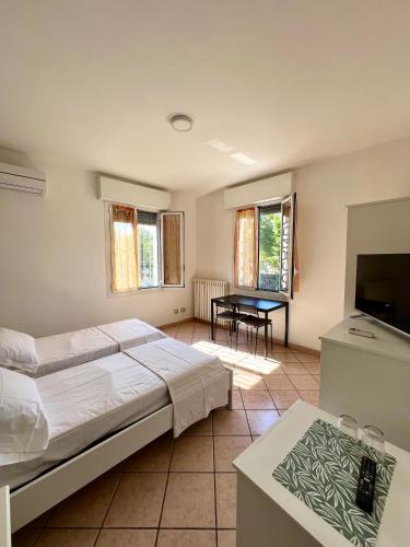 a bedroom with a bed and a table and a television at Locanda Casa Ascari in Nonantola