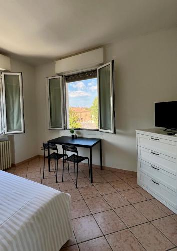 a bedroom with a table and chairs and a window at Locanda Casa Ascari in Nonantola