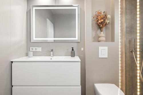 a white bathroom with a sink and a mirror at Luxury Villa in Golden Circle with hot tub in Selfoss