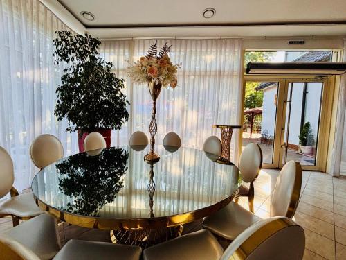 a dining room with a glass table and chairs at Bunika's - Cabana Stejarul in Baisa
