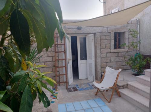a white chair sitting in front of a door at La Coloniale San Pantaleo in San Pantaleo