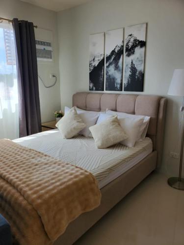 a bedroom with a large bed with pillows on it at VERDANT by Vista Manors Deluxe Rooms with Balcony, Gym and Swimming Pool in Puerto Princesa City