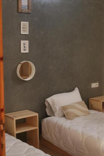 a bedroom with a bed and a mirror and two tables at Surf & bask HOME in Tamraght Ouzdar