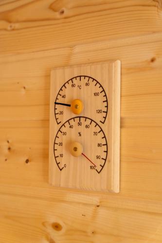 a wooden clock on a wooden wall at Domki Wierzbówka in Mielno