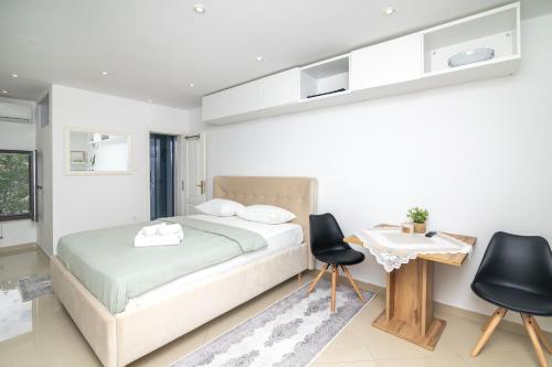a bedroom with a bed and two chairs and a table at Dida moj in Senj