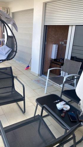 a patio with two chairs and a table on a balcony at Sunrise apartmani in Bar