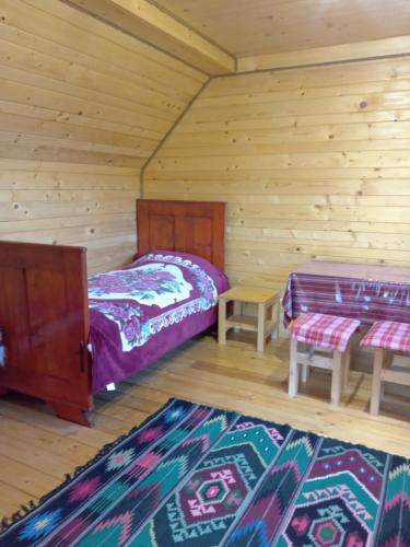 a bedroom with two beds in a log cabin at Садиба Кичера in Petrashani