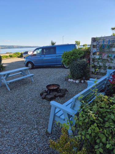 a parking lot with two benches and a fire pit at Firthview House in Kirn