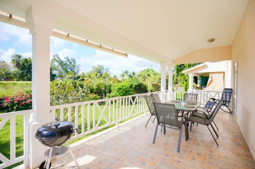 a patio with a table and chairs and a grill at Grand Gaube Golf Sea View Apartment in Mauritius