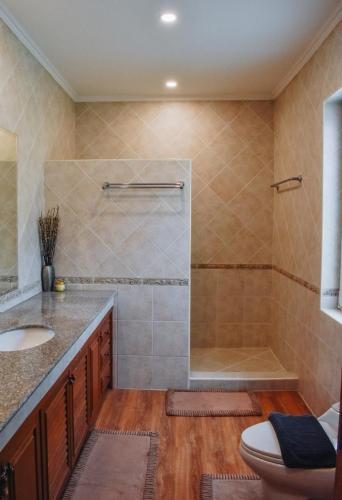 a bathroom with a shower and a toilet and a sink at The Pool House Pattaya No.8 in Pattaya South
