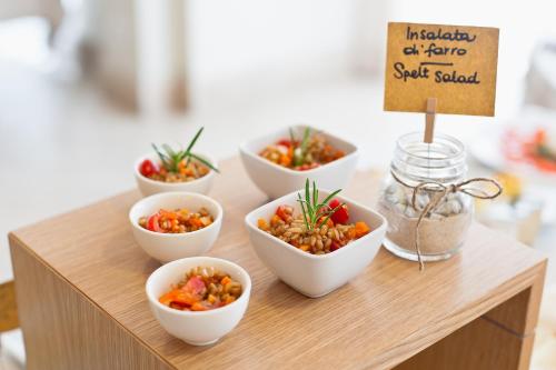 a table with four bowls of food on it at Hotel Stella Della Versilia in Marina di Massa