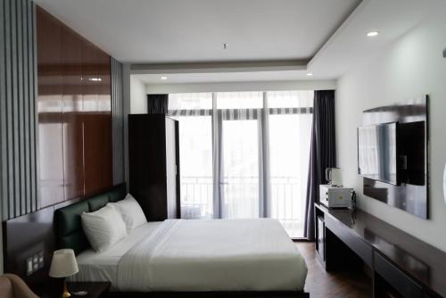 a hotel room with a bed and a large window at Mama Hotel And Apartment - Free Sauna And Gym in Da Nang