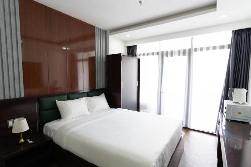 a bedroom with a bed and a large window at Mama Hotel And Apartment - Free Sauna And Gym in Da Nang