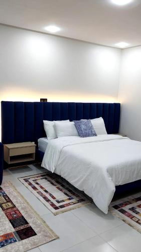 a bedroom with a large bed with a blue headboard at Studio Chefchaoun in Deroua