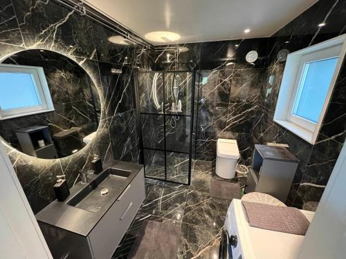 a bathroom with a sink and a mirror at Modern Lakeside Hideaway in Örebro