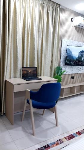 a desk with a laptop and a blue chair at Studio Chefchaoun in Deroua